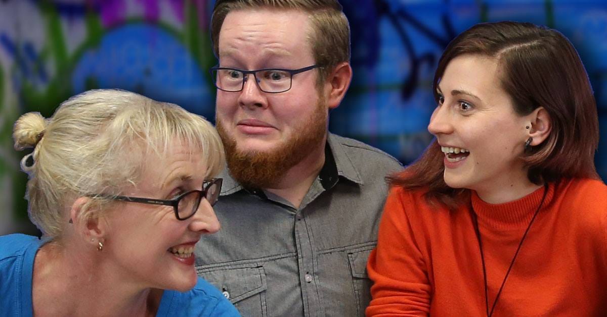 Three actors look at each other with melodramatic facial expressions. Mark has a beard.