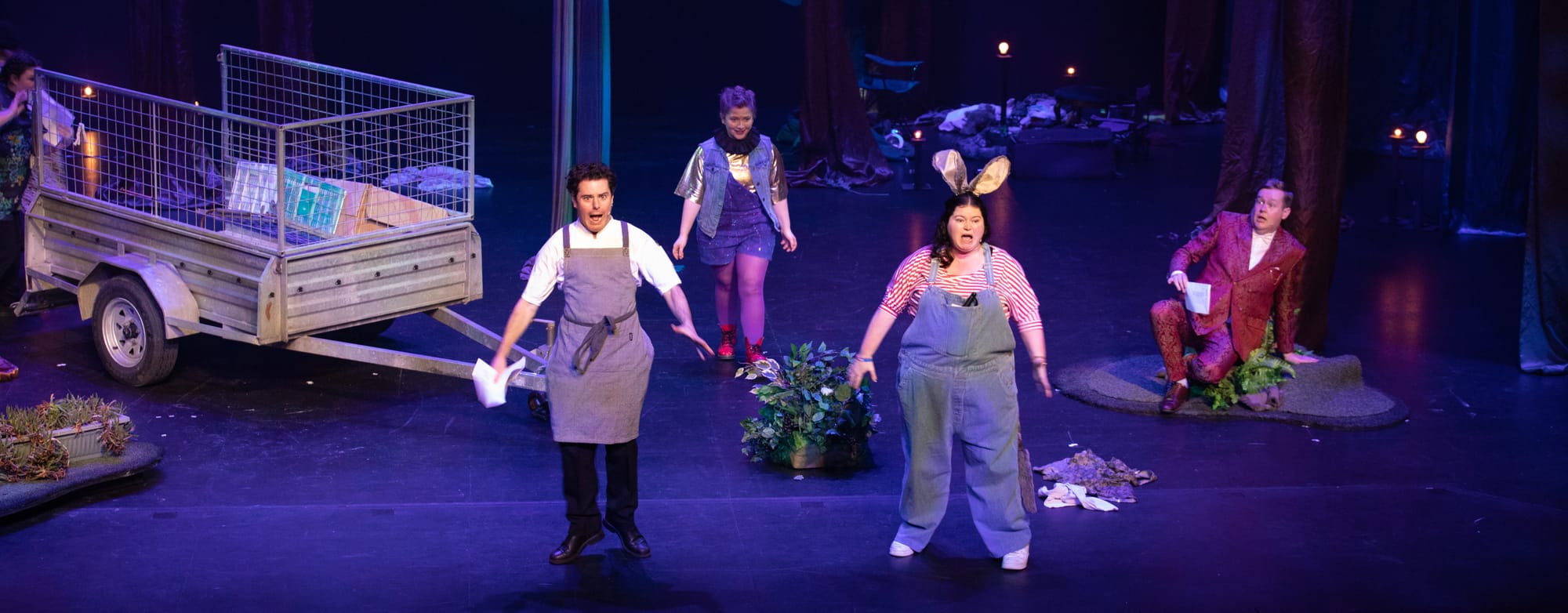 Flute screaming in an apron, Puck looking on mischievously, Bottom screaming with donkey ears, and Starveling looking terrified.