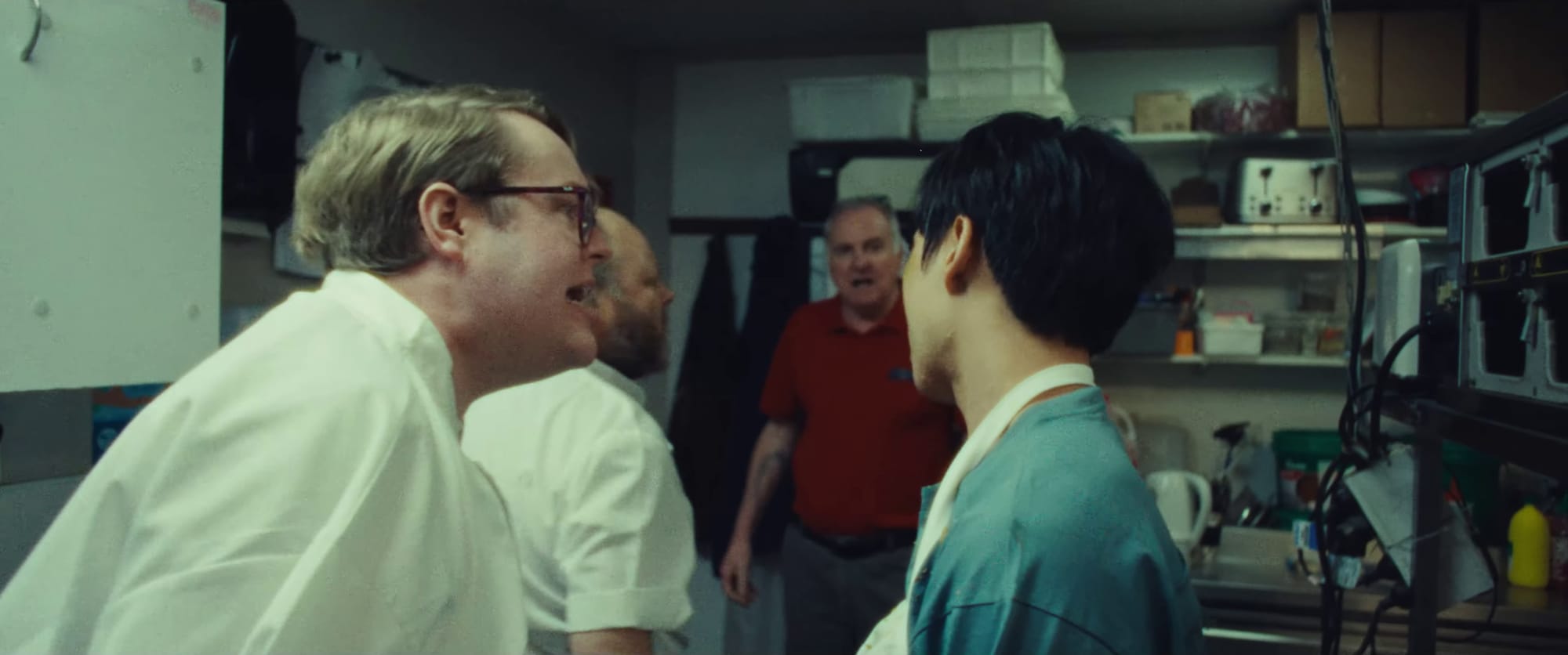 Mark dressed as a chef shouting at Layone who is a waiter. In the background are a second chef and the manager, who are both also aggressive.