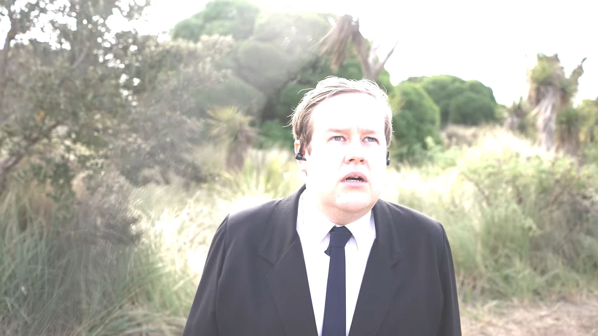 Mark Darbyshire as a government agent looking up at a bright light in the sky.